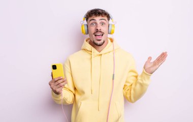 Genç yakışıklı adam kendini mutlu hissediyor ve inanılmaz bir şeye hayret ediyor. müzik konsepti