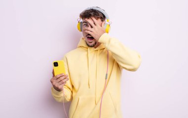 Genç, yakışıklı adam şok olmuş, korkmuş ya da korkmuş görünüyor. müzik konsepti