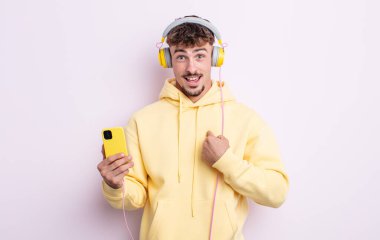 Genç ve yakışıklı bir adam mutlu hissediyor ve heyecanla kendini işaret ediyor. müzik konsepti