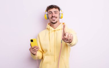 Genç yakışıklı adam gururla gülümsüyor ve kendinden emin bir numara oluyor. müzik konsepti