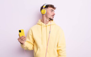 Profilde genç yakışıklı bir adam hayal kuruyor, hayal kuruyor ya da hayal kuruyor. müzik konsepti