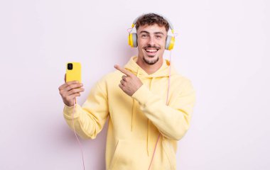 Genç yakışıklı adam heyecanlı ve şaşırmış görünüyor. müzik konsepti