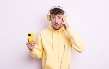 Genç yakışıklı adam şaşırmış görünüyor, yeni bir düşünce, fikir ya da konsept fark ediyor. müzik konsepti