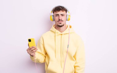 Genç ve yakışıklı bir adam üzgün ve mızmızlanıyor. Mutsuz bir bakışı var ve ağlıyor. müzik konsepti