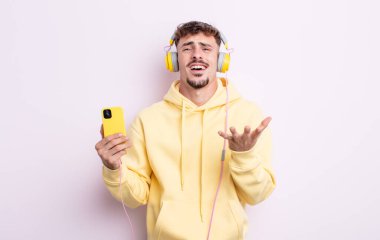 Genç yakışıklı adam umutsuz, sinirli ve stresli görünüyor. müzik konsepti
