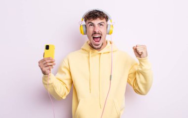 Genç yakışıklı adam sinirli bir ifadeyle agresif bir şekilde bağırıyor. müzik konsepti