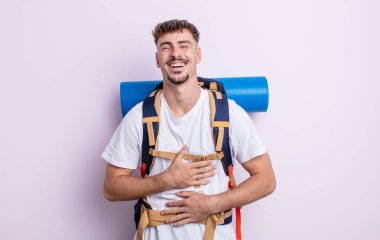 Genç yakışıklı bir adam komik bir şakaya yüksek sesle gülüyor. Yürüyüş konsepti