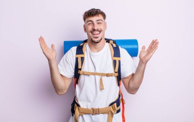 Genç yakışıklı adam kendini mutlu hissediyor ve inanılmaz bir şeye hayret ediyor. Yürüyüş konsepti