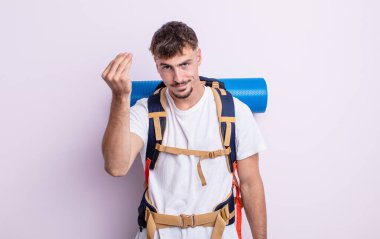 Genç yakışıklı adam kapiş ya da para hareketi yapıyor, sana ödemeni söylüyor. Yürüyüş konsepti