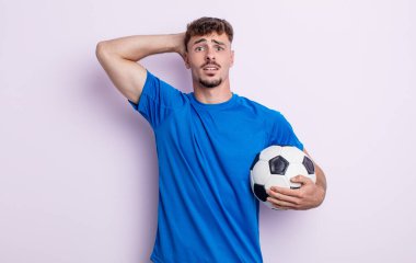 Genç ve yakışıklı bir adam stresli, endişeli ya da korkmuş hissediyor. Elleri başının üstünde. futbol kavramı