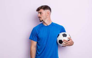 Profilde genç yakışıklı bir adam hayal kuruyor, hayal kuruyor ya da hayal kuruyor. futbol kavramı