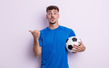 İnanamadığı için şaşırmış genç ve yakışıklı bir adam. futbol kavramı