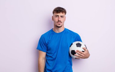 Genç ve yakışıklı bir adam üzgün ve mızmızlanıyor. Mutsuz bir bakışı var ve ağlıyor. futbol kavramı