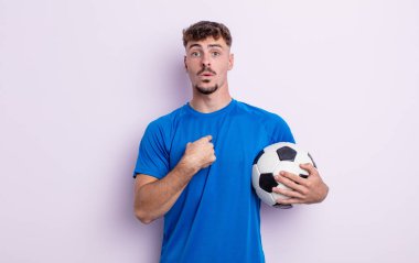 Şok olmuş ve ağzı açık, kendini işaret eden genç ve yakışıklı bir adam. futbol kavramı