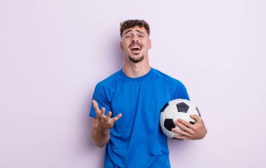 Genç yakışıklı adam umutsuz, sinirli ve stresli görünüyor. futbol kavramı