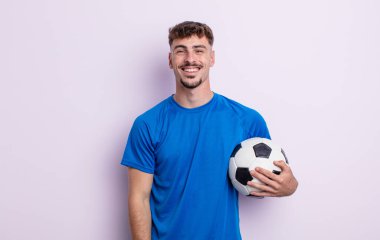 Genç yakışıklı adam mutlu ve hoş bir şekilde şaşırmış görünüyor. futbol kavramı