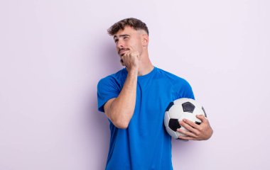 Genç yakışıklı düşünen, kuşkulu ve kafası karışık bir adam. futbol kavramı