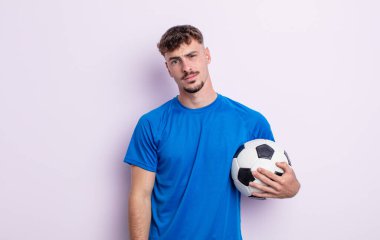 Genç yakışıklı adam şaşkın ve şaşkın hissediyor. futbol kavramı