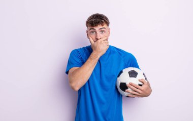 young handsome man covering mouth with hands with a shocked. soccer concept