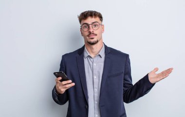 Genç yakışıklı adam şaşkın, şaşkın ve şüpheci hissediyor. iş kavramı