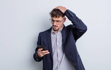 Kafası karışmış, kafası karışmış, kaşınan genç, yakışıklı bir adam. iş kavramı