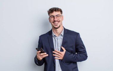 Genç yakışıklı bir adam komik bir şakaya yüksek sesle gülüyor. iş kavramı