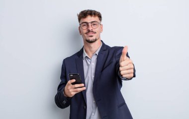 Genç ve yakışıklı bir adam gururlu, olumlu gülümsüyor. iş kavramı