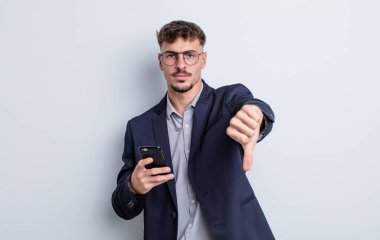 Genç ve yakışıklı bir adam kendini kötü hissediyor, baş parmağını kaldırıyor. iş kavramı