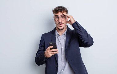 Genç yakışıklı adam mutlu, şaşkın ve şaşırmış görünüyor. iş kavramı