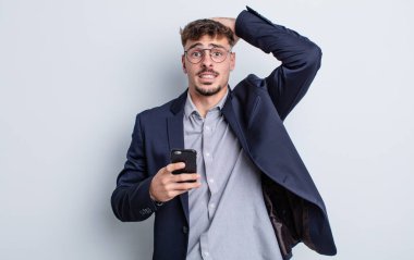 Genç ve yakışıklı bir adam stresli, endişeli ya da korkmuş hissediyor. Elleri başının üstünde. iş kavramı