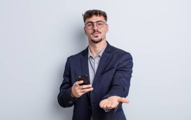 Genç ve yakışıklı bir adam arkadaşça gülümsüyor ve bir konsept sunuyor. iş kavramı