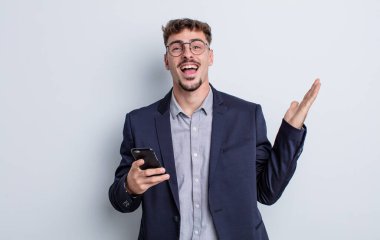 Genç yakışıklı adam kendini mutlu hissediyor ve inanılmaz bir şeye hayret ediyor. iş kavramı