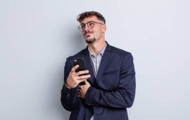 young handsome man shrugging, feeling confused and uncertain. business concept