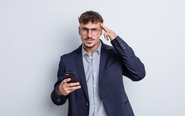 young handsome man feeling confused and puzzled, showing you are insane. business concept