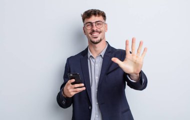 young handsome man smiling and looking friendly, showing number five. business concept