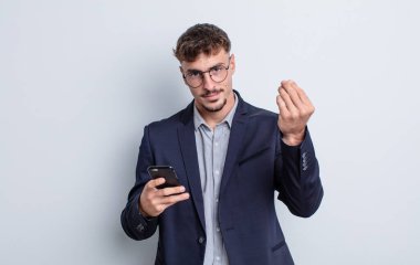 young handsome man making capice or money gesture, telling you to pay. business concept