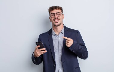 young handsome man looking excited and surprised pointing to the side. business concept