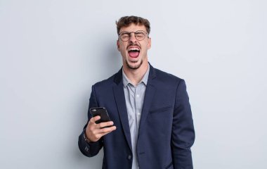 young handsome man shouting aggressively, looking very angry. business concept