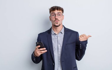 young handsome man looking astonished in disbelief. business concept