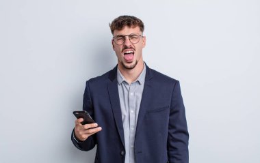 Genç ve yakışıklı bir adam tiksinmiş ve sinirlenmiş hissediyor ve dilini dışarı çıkarıyor. iş kavramı