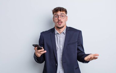 Genç ve yakışıklı bir adam şok olmuş ve şaşırmış hissediyor. iş kavramı