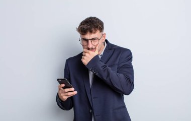 Ağzı ve gözleri açık ve eli çenesinde genç yakışıklı bir adam. iş kavramı