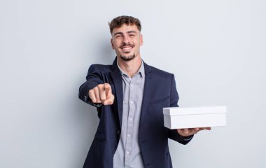 Genç ve yakışıklı bir adam kamerayı işaret ederek seni seçiyor. beyaz kutu paketi