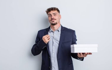 Genç yakışıklı adam kibirli, başarılı, pozitif ve gururlu görünüyor. beyaz kutu paketi