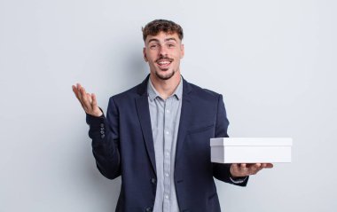 Genç yakışıklı adam kendini mutlu hissediyor, bir çözüm ya da fikir bulduğuna şaşırıyor. beyaz kutu paketi