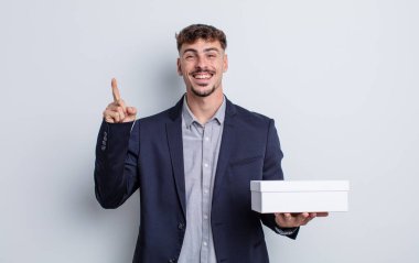 Genç yakışıklı bir adam bir fikri fark ettikten sonra mutlu ve heyecanlı bir dahi gibi hissediyor. beyaz kutu paketi