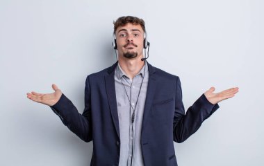 Genç yakışıklı adam şaşkın, şaşkın ve şüpheci hissediyor. tele pazarlamacı kavramı