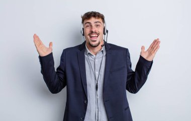 Genç yakışıklı adam kendini mutlu hissediyor ve inanılmaz bir şeye hayret ediyor. tele pazarlamacı kavramı