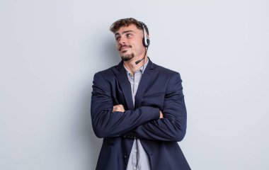 Genç yakışıklı adam omuz silkiyor, kafası karışık ve kararsız. tele pazarlamacı kavramı