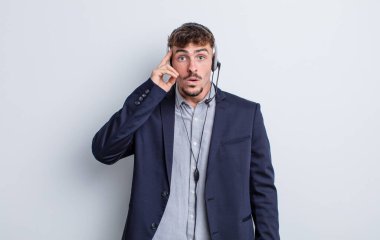 Genç yakışıklı adam şaşırmış görünüyor, yeni bir düşünce, fikir ya da konsept fark ediyor. tele pazarlamacı kavramı